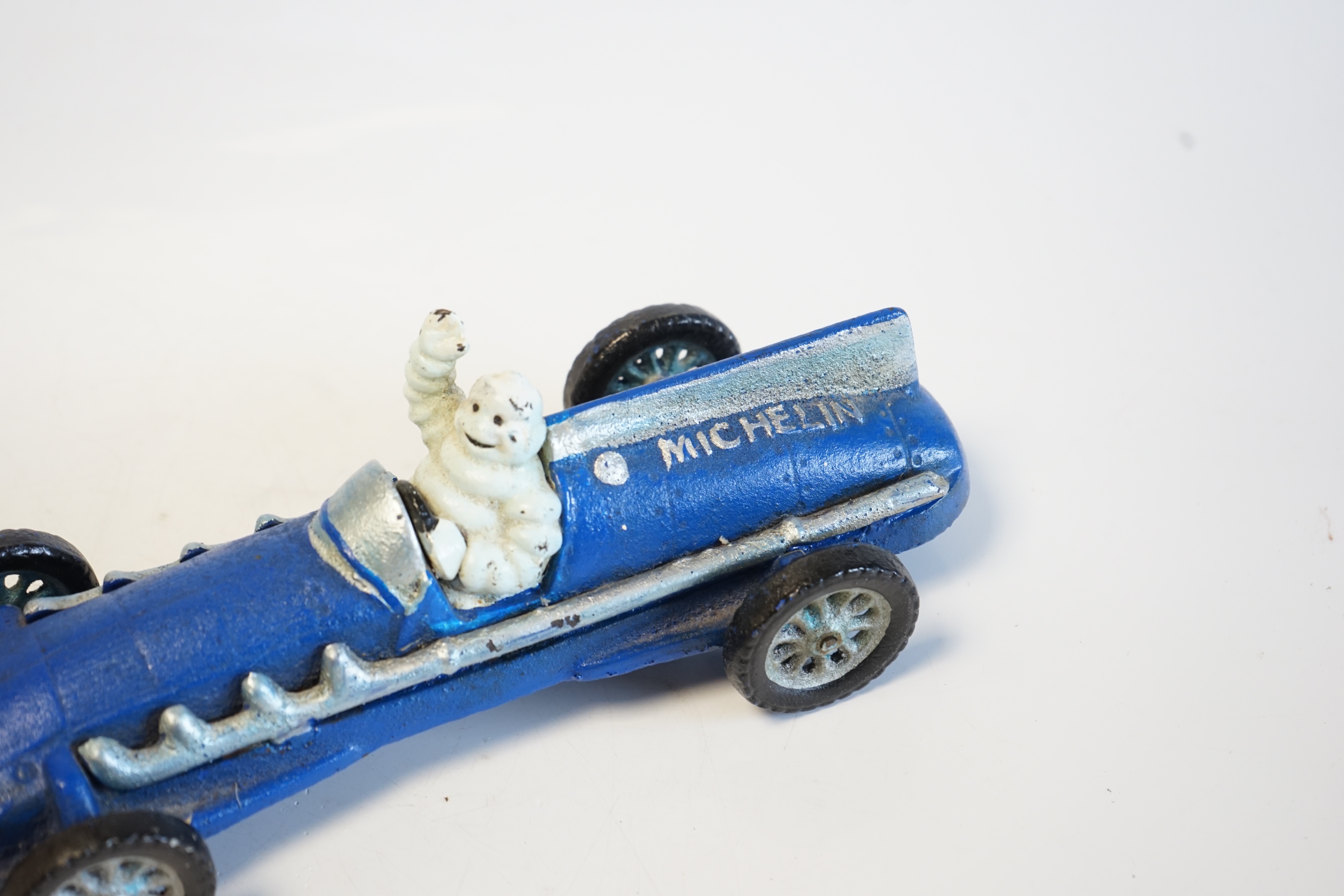 A cast metal Michelin Tyres racing car with Michelin Man driver. Condition fair to good